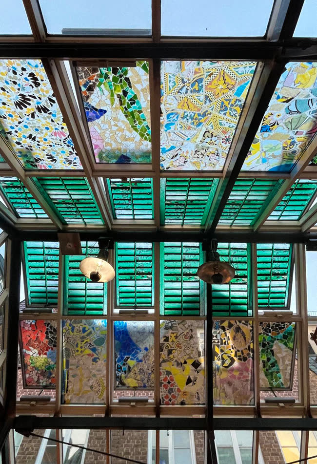 Bunte Glasfenster unter einer Dachkonstruktion aus Glas
