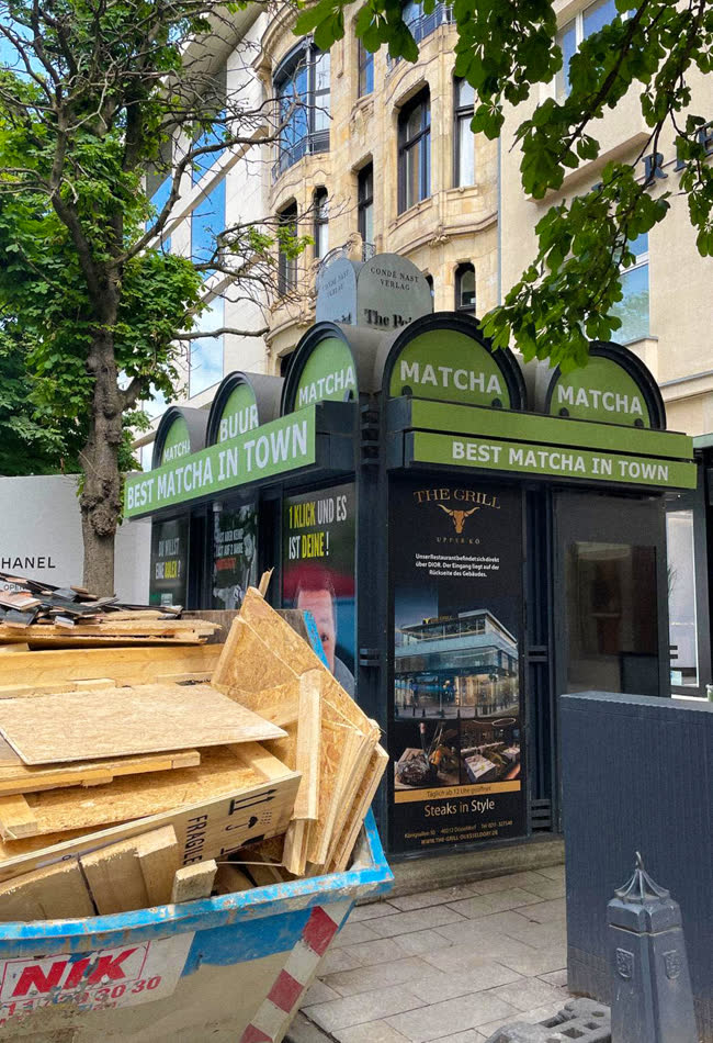 Grüner Kiosk zwischen Altbauten und Bäumen